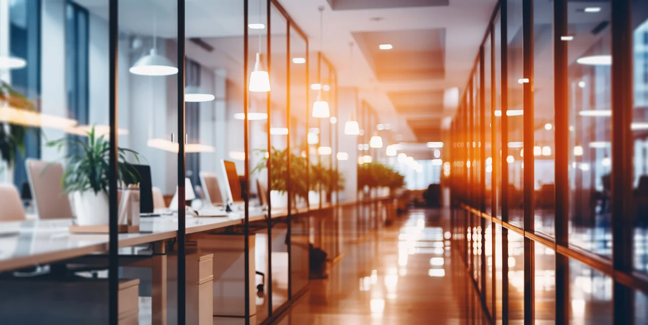 Modern commercial office with glass walls and warm lighting